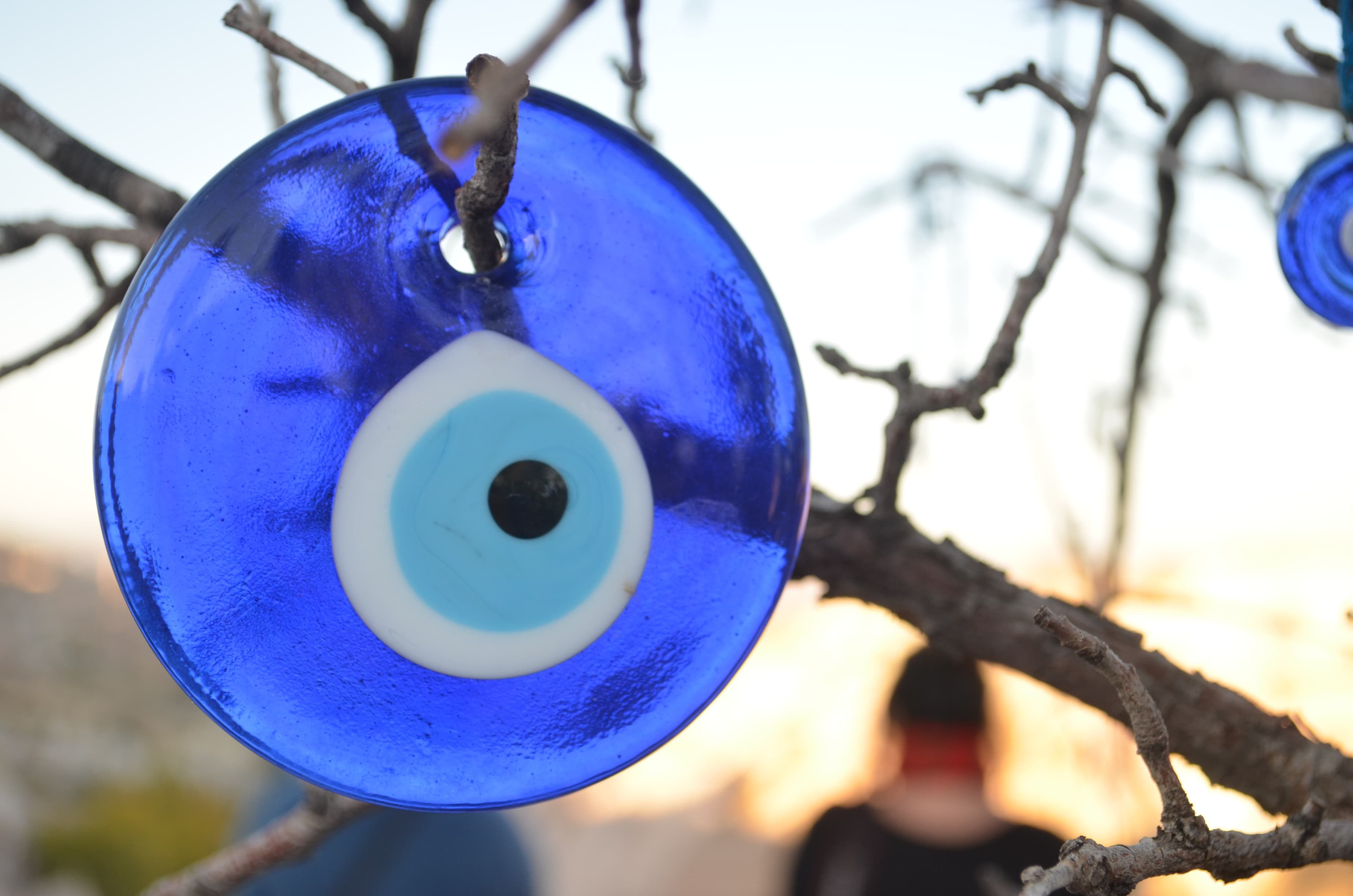 White tree branch hung with hundreds of blue Turkish nazar evil eye beads