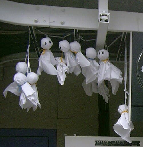 Simple white cloth Teru Teru Bozu doll with drawn smiley face and string for hanging, Japan's traditional weather-wishing charm