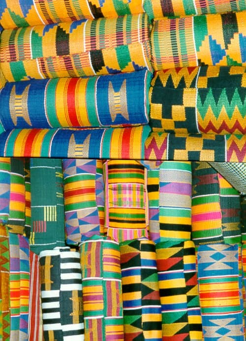 Vibrant kente cloth strip showing interlocking geometric patterns in gold, green, red, and black silk threads