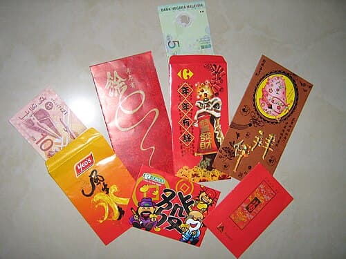 Stack of traditional red envelopes with gold Chinese characters and decorative patterns