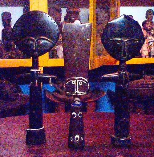 Classic Asante Akuaba fertility doll with disc-shaped head, ringed neck, and minimal body carved in dark wood